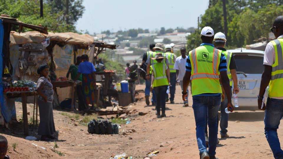 利乐全球最大体育平台的员工和承包商穿着安全背心走在赞比亚的供水项目走廊上.